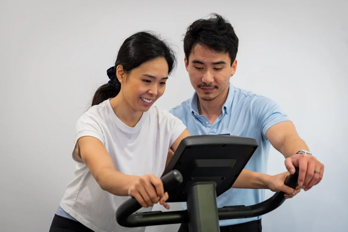 Clyve Tan setting up a patient on the exercise bike at Thorpe Street Health
