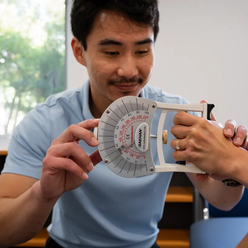The exercise physiologist at Thorpe Street Health testing a patient's grip strength