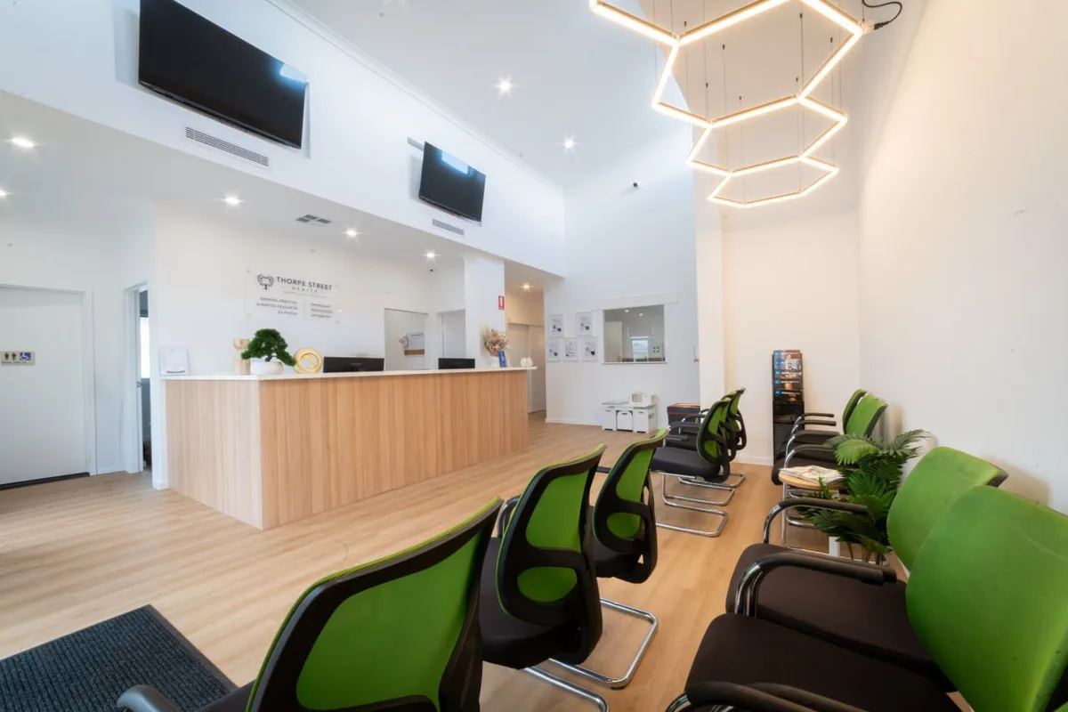 The reception desk and waiting area at Thorpe Street Health, under the hexagon light fitting